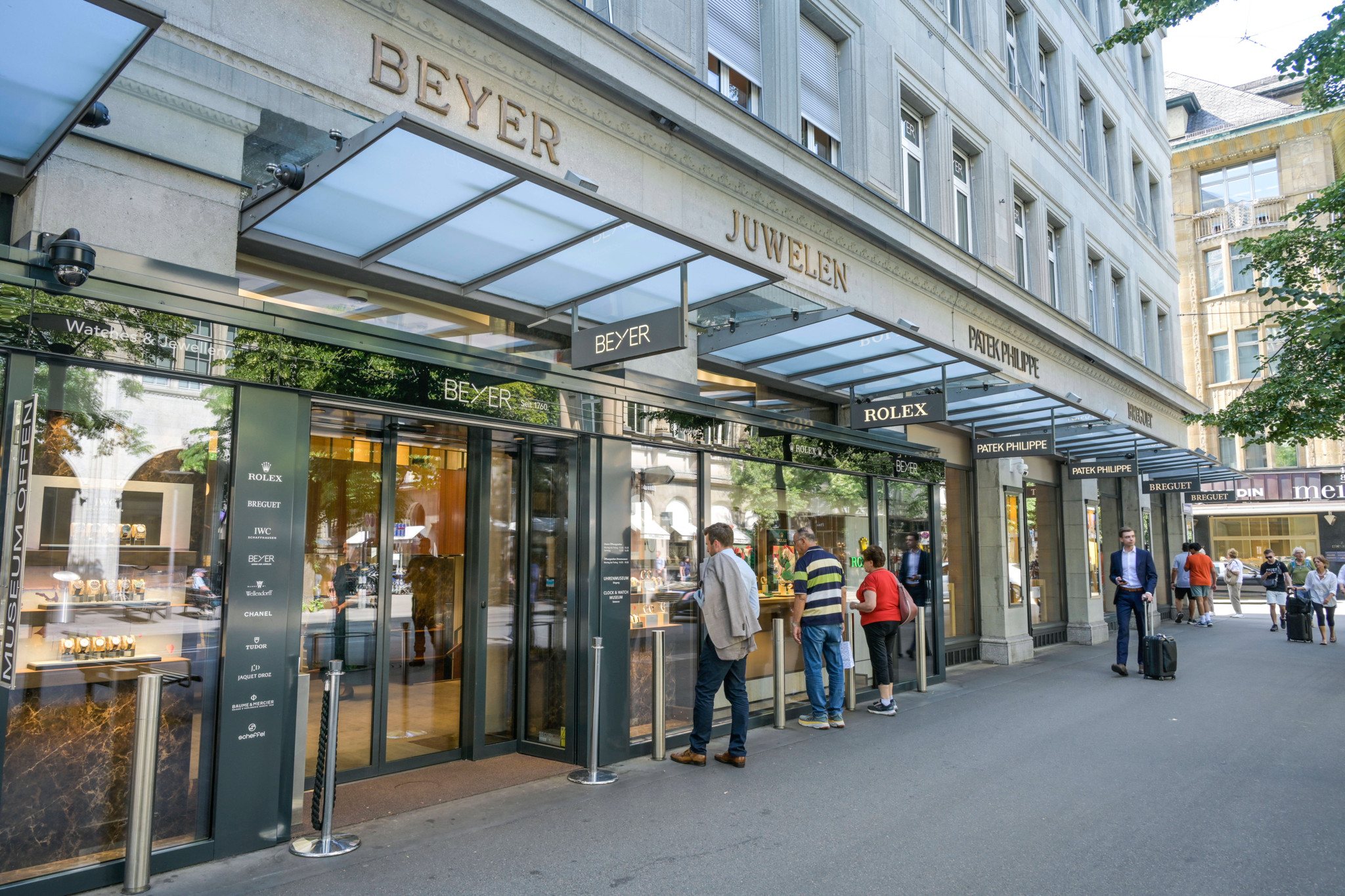 Devanture de la bijouterie Beyer Juwelen sur la Bahnhofstrasse à Zurich, avec des passants devant les vitrines Rolex et Patek Philippe.