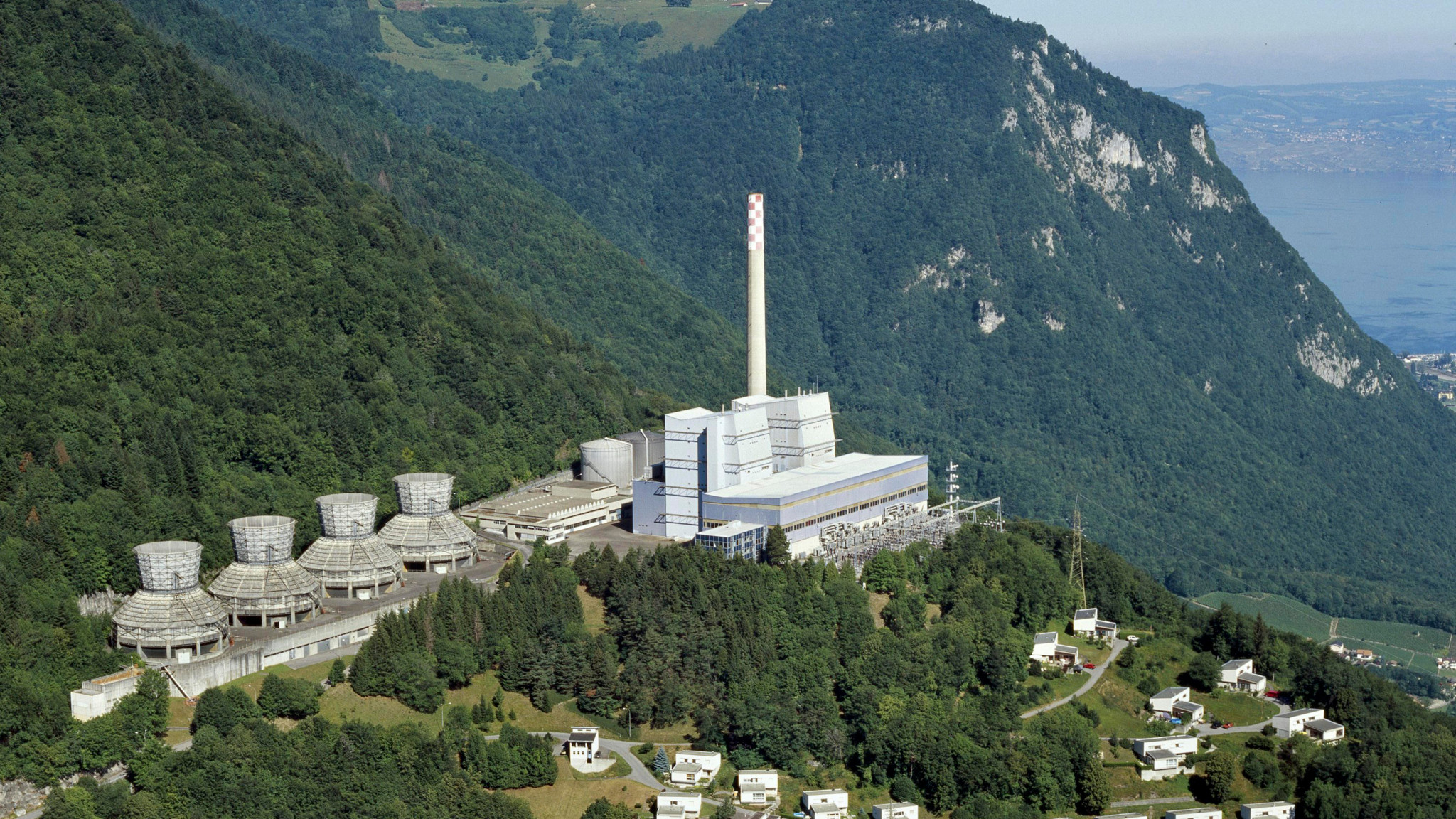 Vue aérienne de la centrale thermique de Chavalon à Vouvry, avec sa cheminée distinctive, nichée entre les Alpes et le lac Léman.