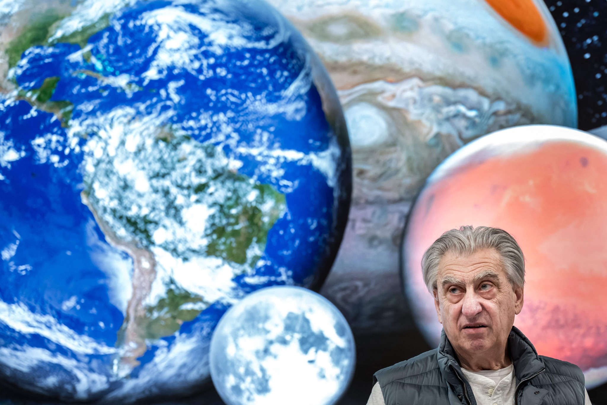 Nick Hayek, CEO du groupe Swatch, devant un fond représentant la Terre, la Lune, Jupiter et Mars, lors d’une conférence de presse à Bienne.