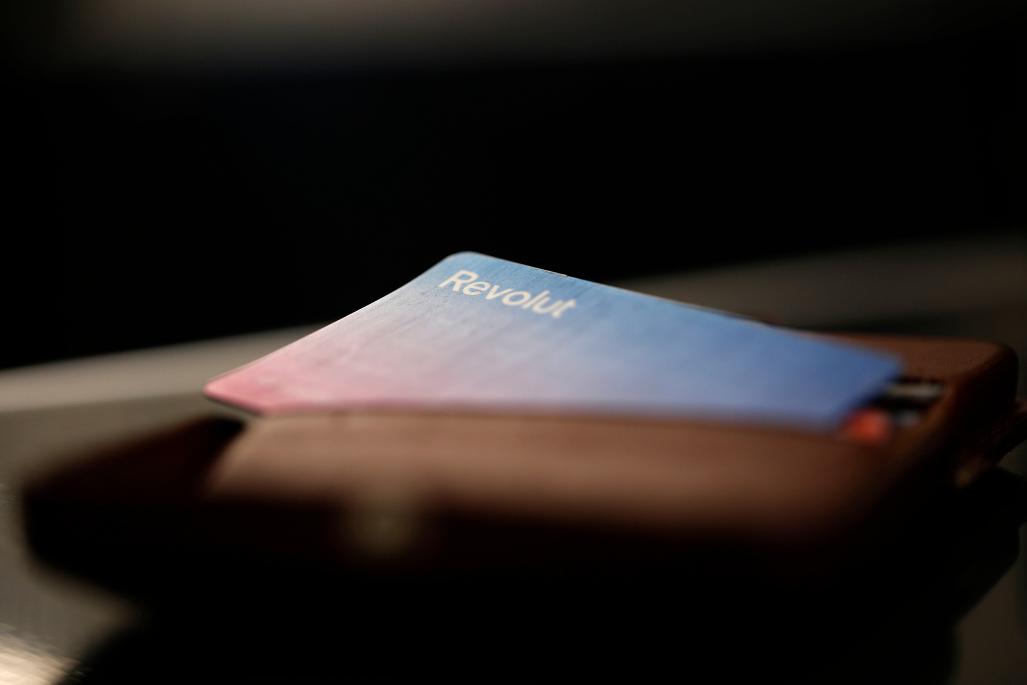 Carte bancaire Revolut sortant d’un portefeuille en cuir.